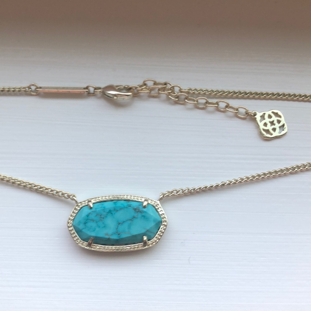 gold kendra scott necklace with blue stone